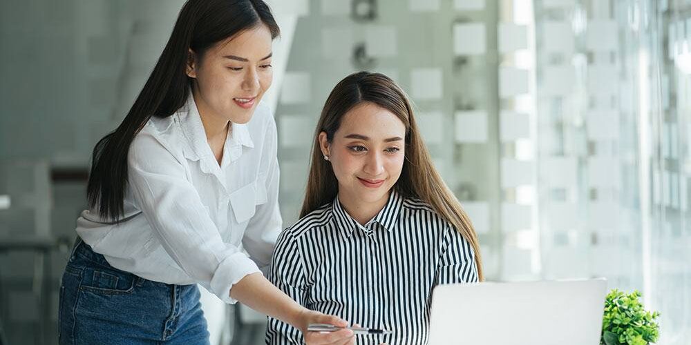 Personalerin und Bewerberin vor einem Laptop bei der Postkorbübung