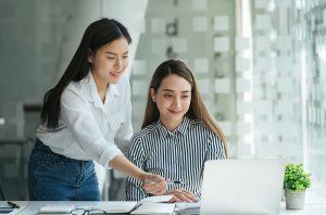 Personalerin und Bewerberin vor einem Laptop bei der Postkorbübung