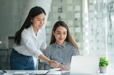 Personalerin und Bewerberin vor einem Laptop bei der Postkorbübung