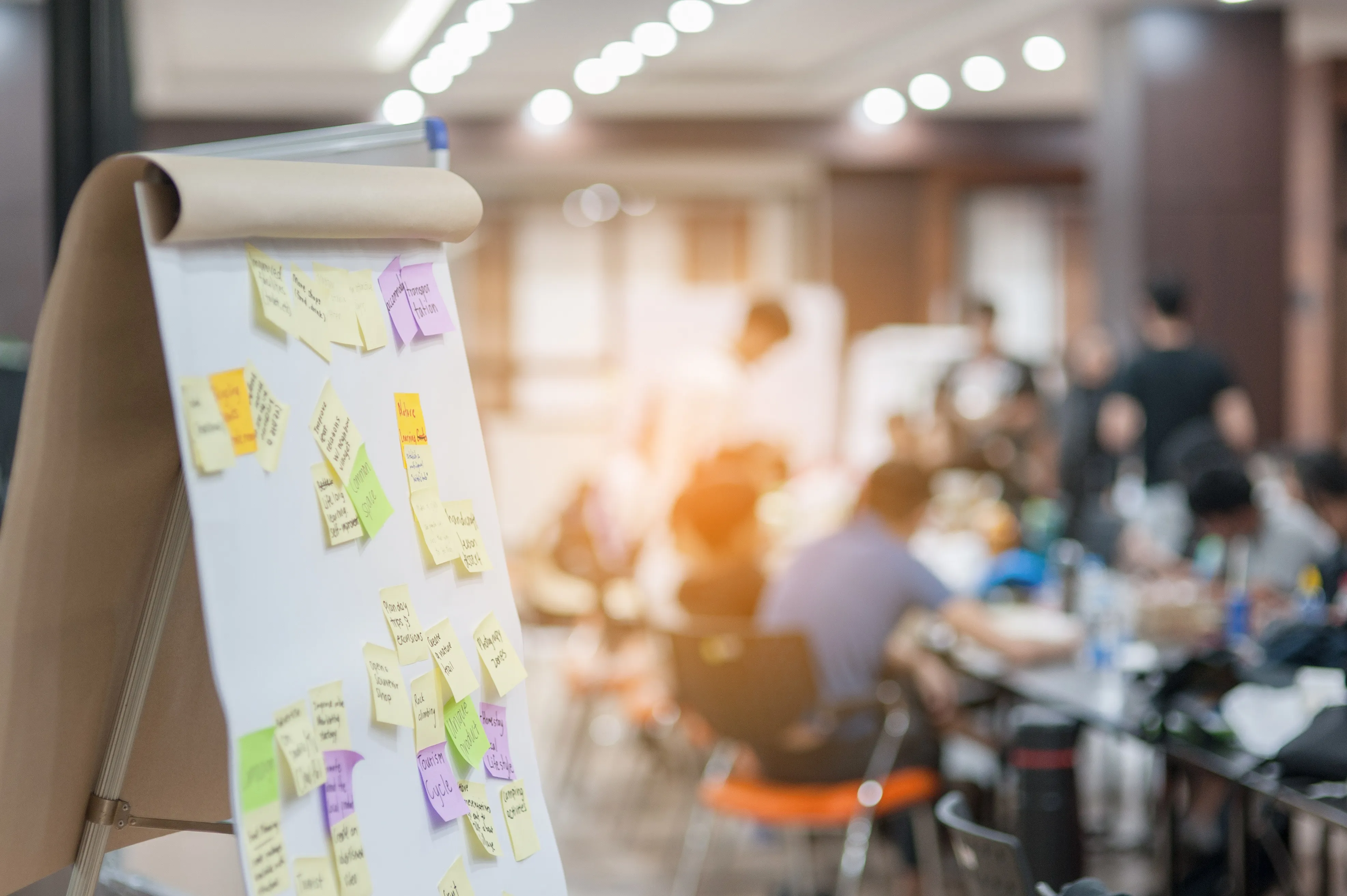 Scrum-Board im Vordergrund eines Agile Transformation-Coaching