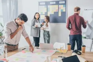 Ein Team diskutiert vor einem Scrum-Board