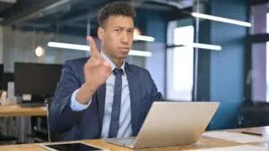 Junger Mann sagt nein durch Fingerbewegung