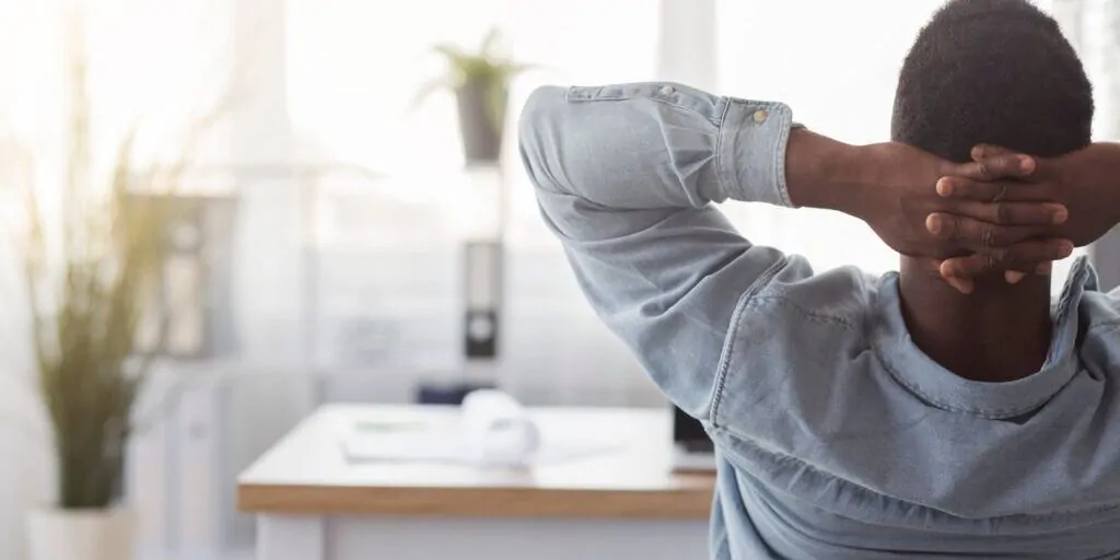 Traumjob finden: Ein Mann sitzt am Schreibtisch und denkt nach.