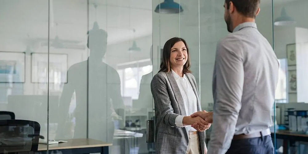 Chefin begrüßt neuen Mitarbeiter